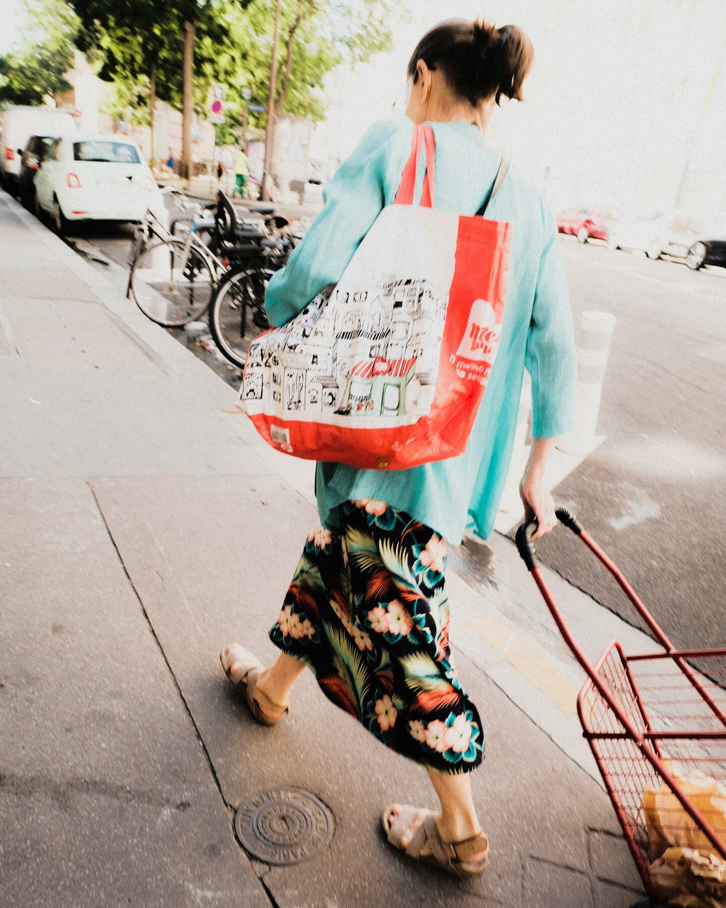 A woman walking through her neighborhood with grocery bags