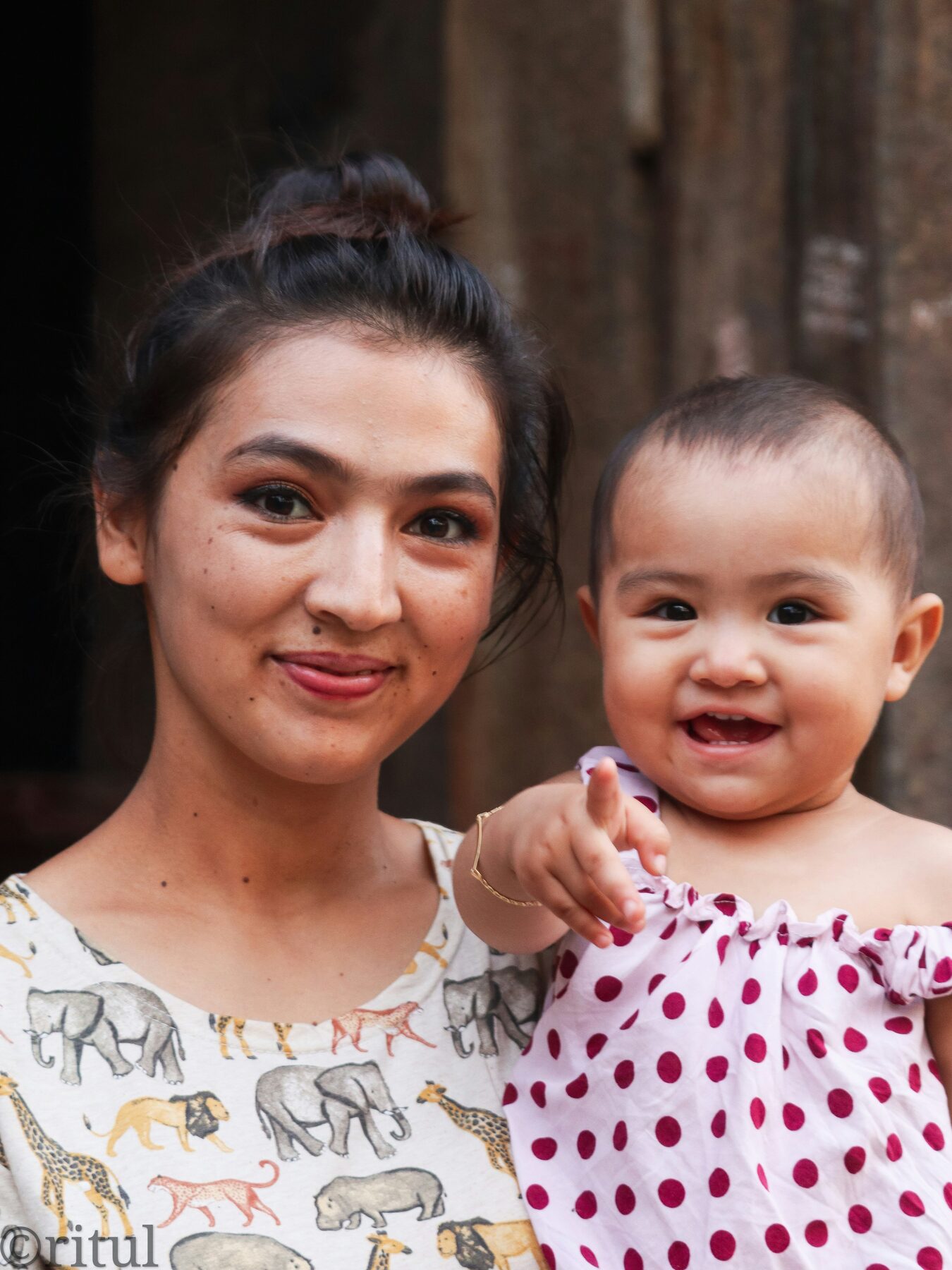A mother holding her young child close, golden hour