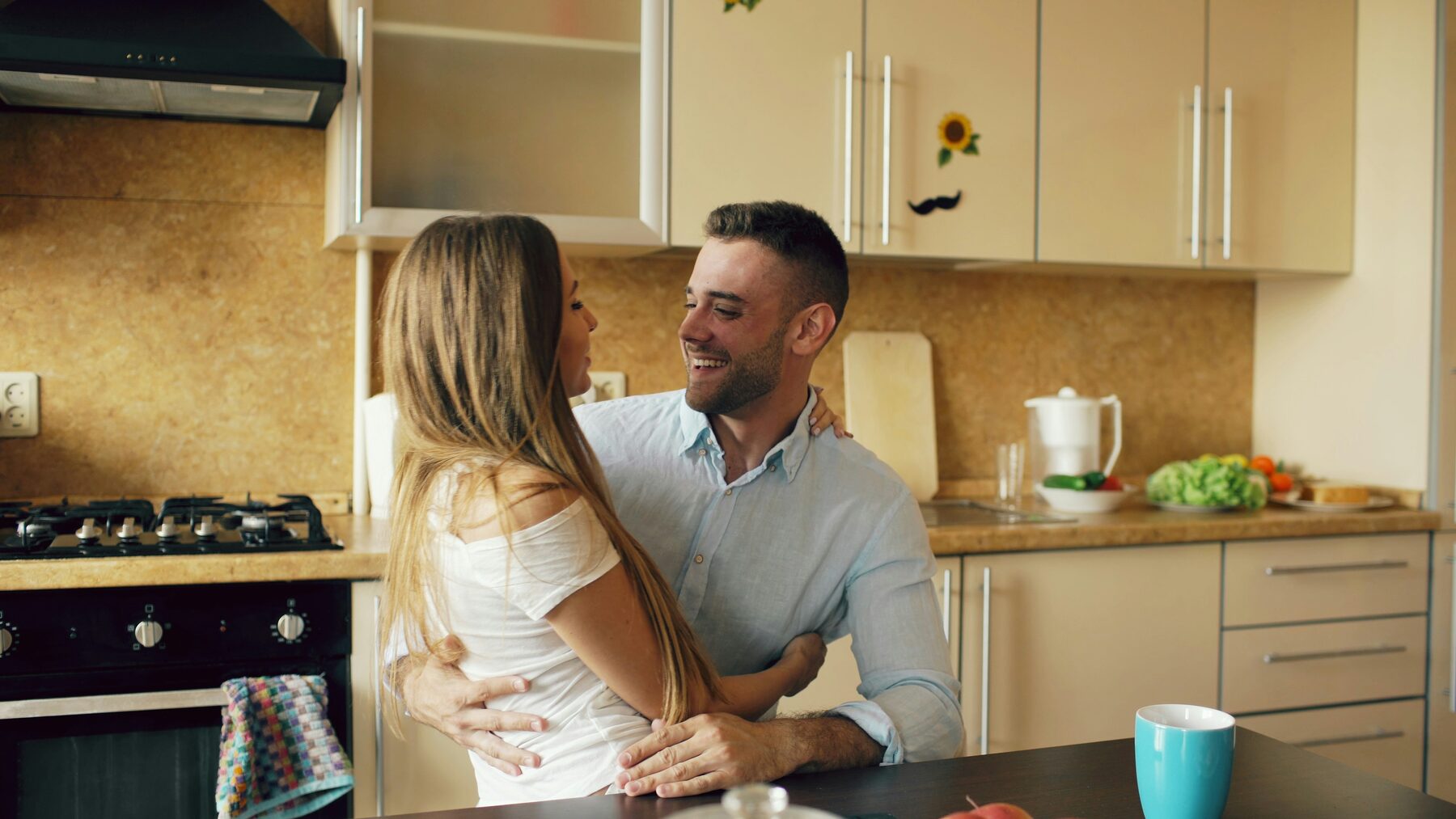 A couple cooking together in a warm, lived-in kitchen
